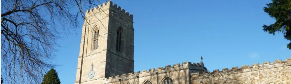 Header image - St Peter's Church, Church Langton - The image shows a blue sky behind the sunlit tower to the left, with the body of the church to the right